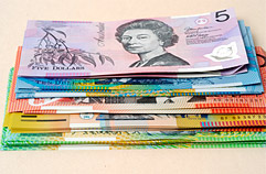 Stack of banknotes with the $5 banknote on top.